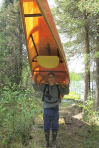 Author David David Atcheson stands with Canoe